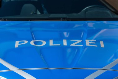 Yakın çekim yansıma beyaz harfler ve mavi arka plana sahip bir Alman polis araba