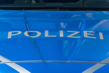 Yakın çekim yansıma beyaz harfler ve mavi arka plana sahip bir Alman polis araba