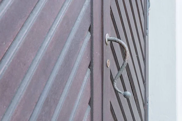 Vintage door handle on a wooden front door, Germany