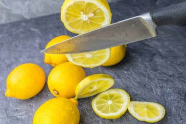 Keskin bir mutfak bıçağı dilimler halinde düşen limon keser