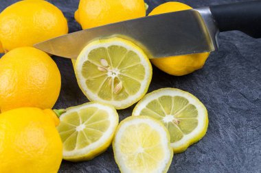 Keskin bir mutfak bıçağı dilimler halinde düşen limon keser
