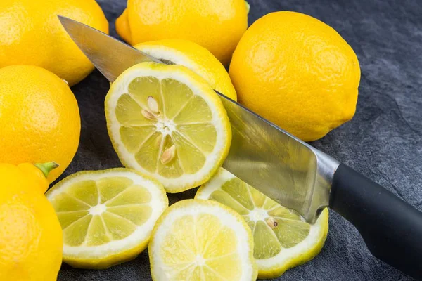 Keskin bir mutfak bıçağı dilimler halinde düşen limon keser