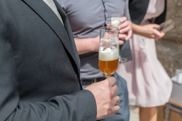 A newlywed husband and his best man drinking a glass of beer, Germany