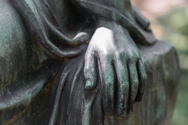 Almanya 'da bir parkta bronz bir kadının kadın elinin detaylı fotoğrafı.