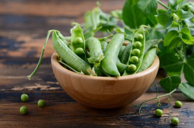 Rustik ahşap zemin üzerine taze organik yeşil bezelye.