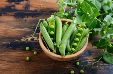 Rustik ahşap zemin üzerine taze organik yeşil bezelye.