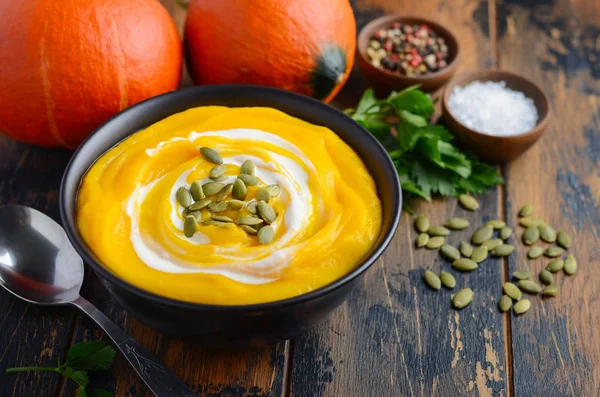 Kürbiscremesuppe Mit Sahne Und Kürbiskernen Auf Rustikalem Holztisch — Stockfoto