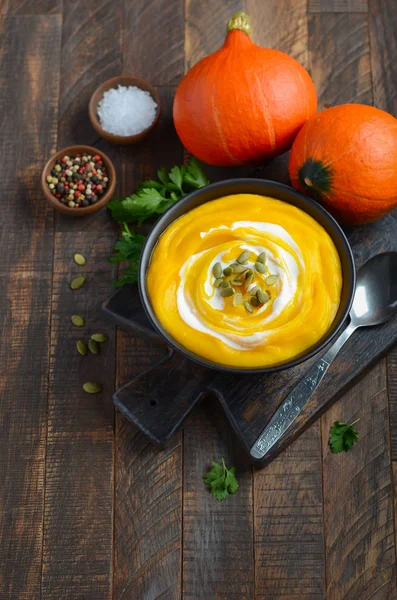 Kürbiscremesuppe Mit Sahne Und Kürbiskernen Auf Rustikalem Holztisch — Stockfoto