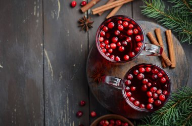 Cranberries ile kırmızı şarap mulled. Tatil kavramı çam dalları ve baharat ile dekore edilmiş.