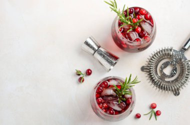 Kızılcık ve beyaz beton arka planda, üstten görünüm, biberiye ile soğuk serinletici içecek kopyalama alanı