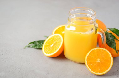 Gri beton zemin, seçici odak, kopya alanı bir kavanoza taze portakal suyu.