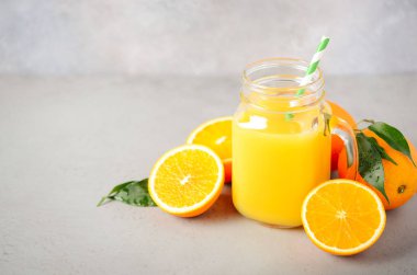 Gri beton zemin, seçici odak, kopya alanı bir kavanoza taze portakal suyu.