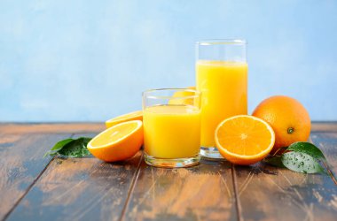 Seçici odak eski ahşap masada bir bardak taze portakal suyu.