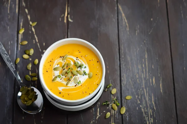 Kürbiscremesuppe Mit Sahne Und Kürbiskernen Auf Dunklem Rustikalem Holztisch — Stockfoto