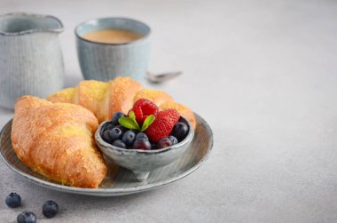 Taze kruvasanlar çilek gri beton zemin, seçici odak ile.