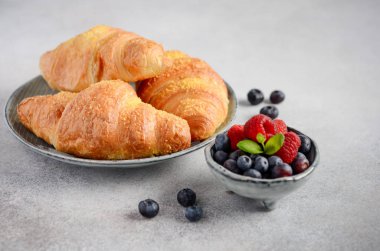 Taze kruvasanlar çilek gri beton zemin, seçici odak ile.