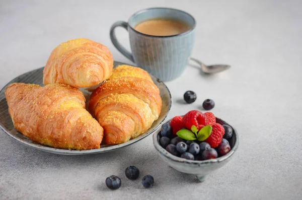 Taze kruvasanlar çilek gri beton zemin, seçici odak ile.