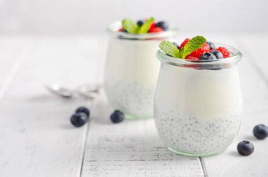 Chia tohum puding Beyaz ahşap bir masa seçici odak üzerinde taze çilek ile.
