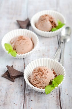 Ahşap bir masa üzerinde beyaz kase çikolatalı dondurma, seçici odak.