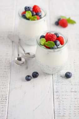 Chia tohum puding Beyaz ahşap bir masa seçici odak üzerinde taze çilek ile.