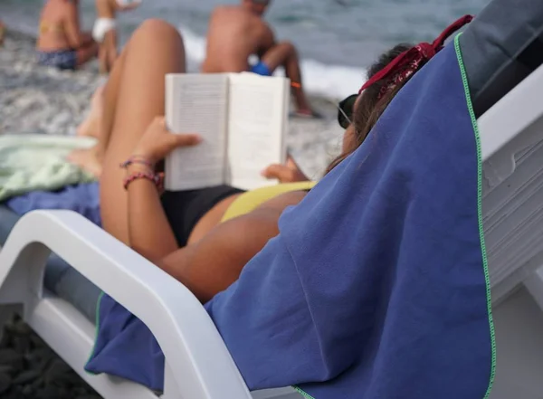 Relaxing with a good book at the beach. Selective focus
