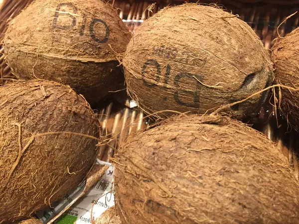 在农贸市场摊位上展示的生物椰子堆 — 图库照片