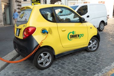 Rome, Italy - August 10, 2018: Share'ngo electric car being charged at an electric charging station clipart