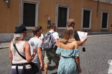 Roma, Italya-9 Ağustos 2018: tanınmayan geri Roma sokaklarında yürüyüş genç turistler döndü turistik bir harita bakıyor