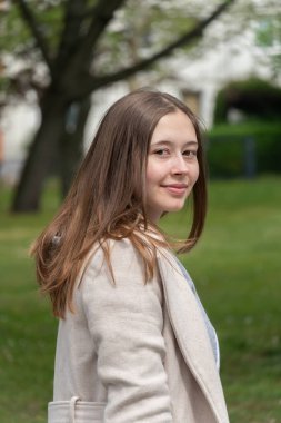 Güzel genç kadın gülümseyerek poz ve kameraya bakarak