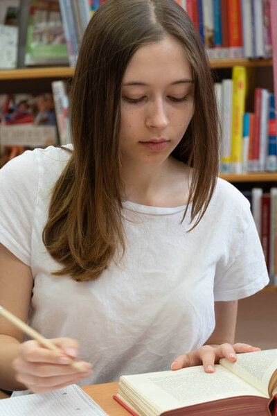 Student doing her homework in the school library
