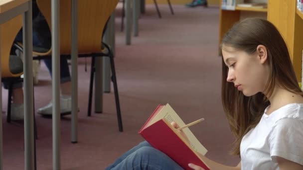 Estudiante Absorbida Leyendo Sentada Suelo Biblioteca Escuela — Vídeo de stock