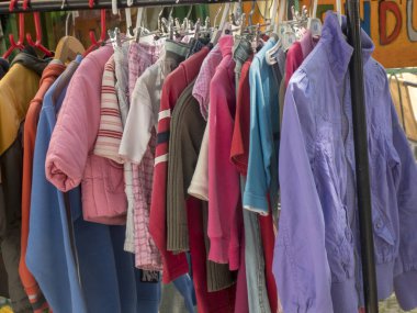 Bit pazarında rafta asılı renkli ikinci el giysi ve ceketler