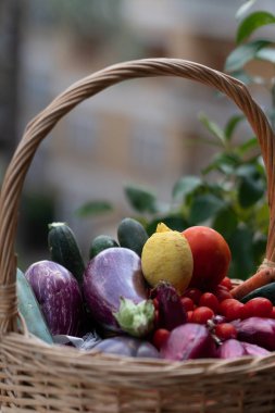 Hasır sepet taze ve olgun çiftlik sebze dolu: patlıcan, kabak, havuç, domates, limon ve arpacık