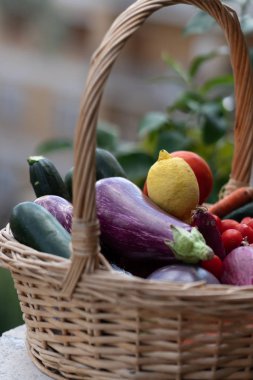 Hasır sepet taze ve olgun çiftlik sebze dolu: patlıcan, kabak, havuç, domates, limon ve arpacık