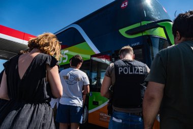 Berlin, Almanya - 23 Temmuz 2019: Otobüs terminalinde flixbus otobüsüne binmeye hazır insanları kontrol eden Alman polisleri geri döndü