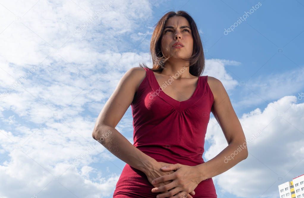 Stomach ache. Young brunette woman suffering with menstrual or abdominal pain