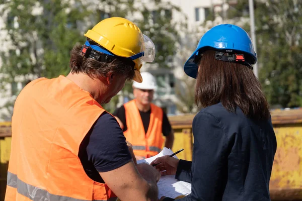 Construction Manager Bär Skyddsjacka Och Hjälm Kontroll Projekt Diskuterar Med — Stockfoto