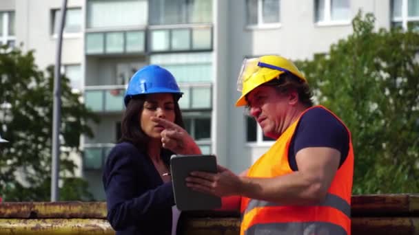 Bauarbeiter Mit Warnweste Helm Und Schutzbrille Überprüfen Den Arbeitsplan Auf — Stockvideo
