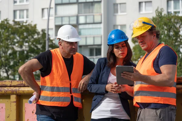 Trois Travailleurs Sur Chantier Portant Gilet Sécurité Casque Des Lunettes Image En Vente