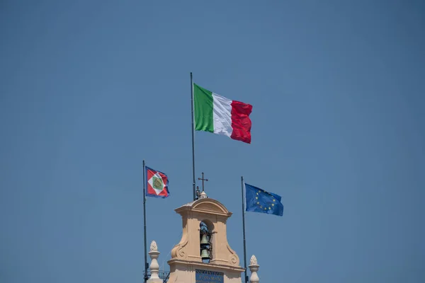 European and Italian flags and Italian Presidential pennant waving outside the Quirinale Palace in Rome, one of the three official residences of the President of the Italy