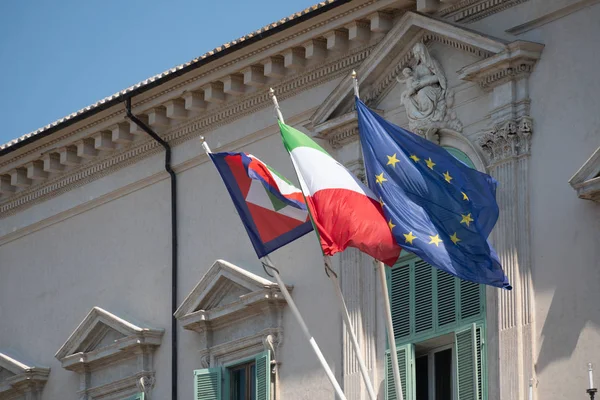 European and Italian flags and Italian Presidential pennant waving outside the Quirinale Palace in Rome, one of the three official residences of the President of the Italy