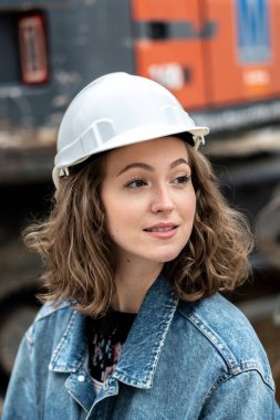 Beyaz koruyucu kask takan sevimli bir fabrika çalışanı.