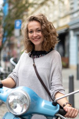 Gülümseyen ve şirin sarışın kız mobiletle poz veriyor.