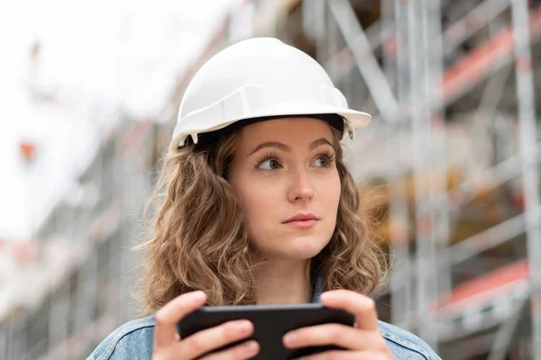 Pensiv Omtänksam Ung Civilingenjör Jobbet Som Håller Sin Mobiltelefon Byggarbetsplatsen — Stockfoto