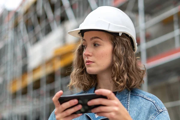 Pensiv Omtänksam Ung Civilingenjör Jobbet Som Håller Sin Mobiltelefon Byggarbetsplatsen — Stockfoto