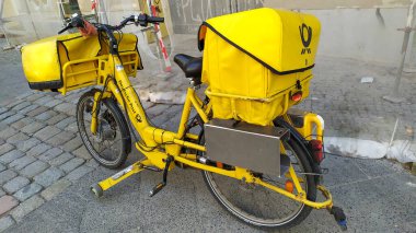 Berlin, Almanya - 28 Mart 2020: Alman Deutsche Post 'un elektrikli bisikleti. Merkezi Bonn 'da bulunan Deutsche Post DHL Grubu bir Alman kurye şirketi ve dünyanın en büyük...