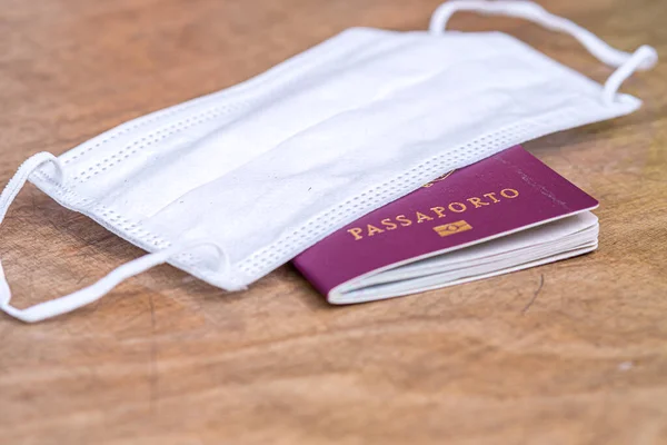 Italian passport and medical mask. Travel restrictions during the epidemic of coronavirus disease or covid-19 and the introduction of quarantine concept