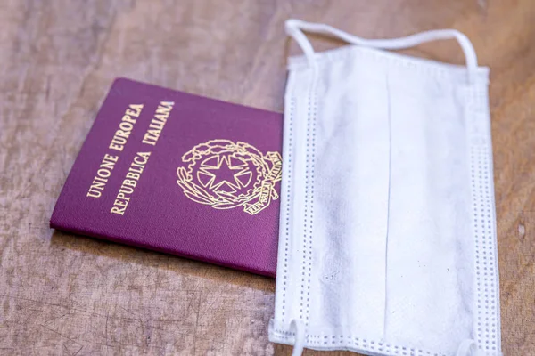 Italian passport and medical mask. Travel restrictions during the epidemic of coronavirus disease or covid-19 and the introduction of quarantine concept