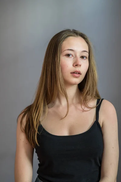 Portret Uroczej Młodej Kobiety Ubranej Koszulkę Pozującej Kamerę Szarym Tle — Zdjęcie stockowe