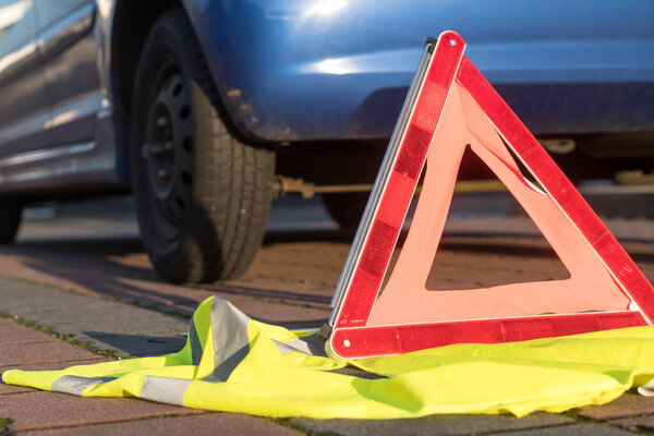 Red triangle warning sign and yellow safety vest